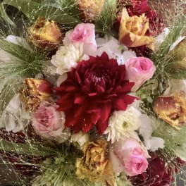 Bouquet of red, pink, and white flowers with wispy grass-like accents