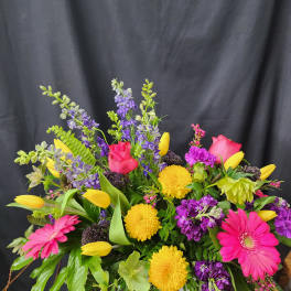 Bright mixed bouquet with pink gerberas, yellow tulips, and purple blooms