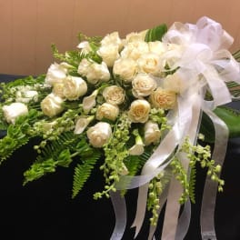 Cream rose bouquet with white ribbon and trailing greenery