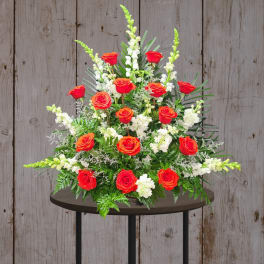 Red roses and white flowers in a large standing arrangement
