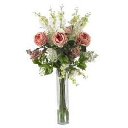 Pink roses in a tall clear glass vase with white filler flowers