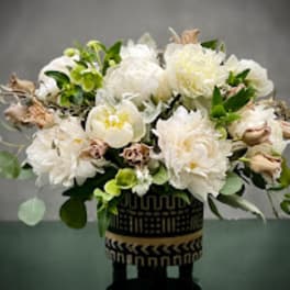 White floral arrangement in a patterned black vase