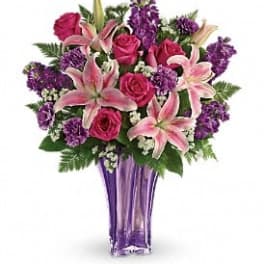 Pink roses and lilies in a purple glass vase