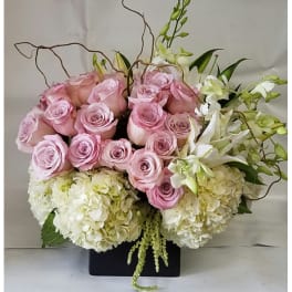 Pink roses and white hydrangeas in a black rectangular vase