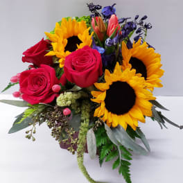 Bouquet of red roses and sunflowers with purple blooms