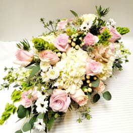 Pink roses and white hydrangeas arranged with white daisies and greenery