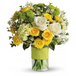 Yellow and white rose bouquet with green mums in a clear glass vase wrapped with a green band.