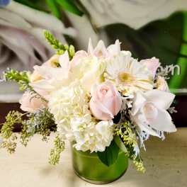 Soft pink and white bouquet in a green glass vase