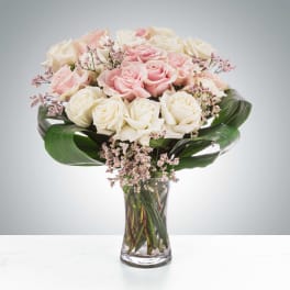 Bouquet of pink and white roses in a clear glass vase