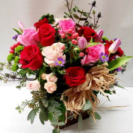 Mixed bouquet of red and pink roses with small purple flowers