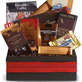Assorted chocolates arranged in a black gift box with a red ribbon