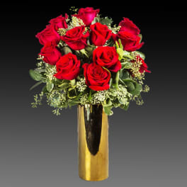 Red roses arranged in a tall gold vase