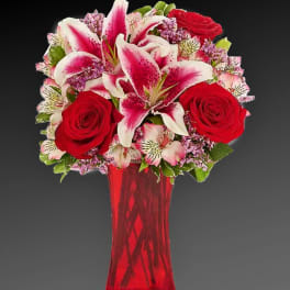 Bouquet of red roses and pink lilies in a red vase