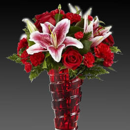 Red roses and pink lilies in a red glass vase