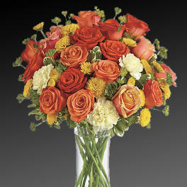 Orange and yellow rose bouquet in a clear glass vase