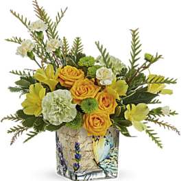 Yellow roses and carnations in a butterfly-patterned glass vase
