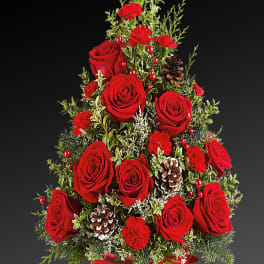 Red roses and carnations arranged in a red bowl with pinecones