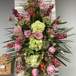 Tall arrangement of pink roses and green hydrangeas with mixed blooms
