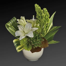 White lilies and green succulents in a white vase