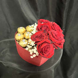 Red roses with gold-wrapped chocolates in a red heart box