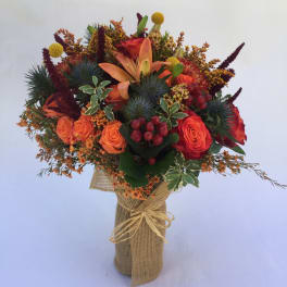 Bouquet of orange and red flowers wrapped in burlap