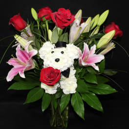 Bouquet of red roses and pink lilies with a white teddy bear in a vase