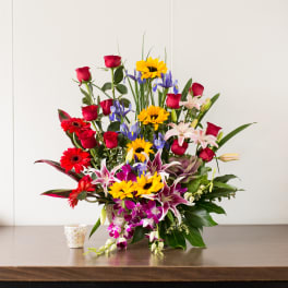 Mixed bouquet with roses, lilies, sunflowers, and irises in a vase