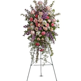 Tall standing floral spray with pink and lavender roses on a metal easel