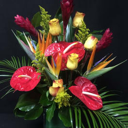 Tropical arrangement with red anthuriums, yellow roses, and bird of paradise