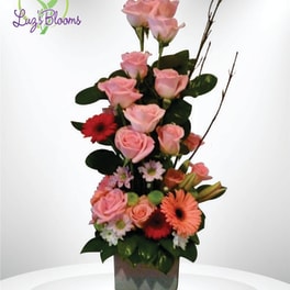 Tall pink rose arrangement with gerbera daisies in a square vase