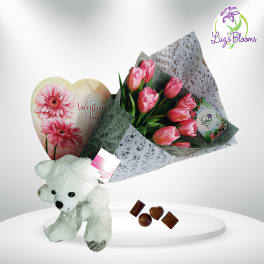 Pink tulip bouquet with a teddy bear, heart card, and chocolates