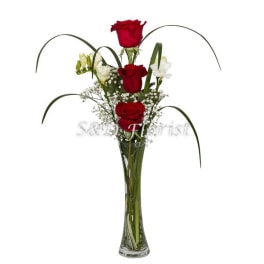 Tall vase arrangement with red roses and white accent flowers