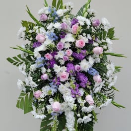 Standing floral spray with pink roses, white daisies, and purple blooms