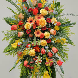 Large standing floral spray with roses, gerbera daisies, and yellow blooms