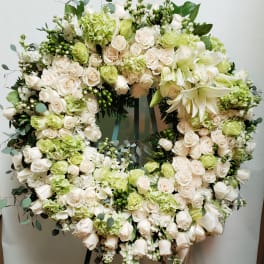 Large circular wreath of white and pale green flowers on an easel