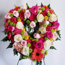 Heart-shaped floral wreath with pink and white roses and bright accent flowers