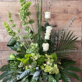 Tall green floral arrangement with white roses in a wooden box