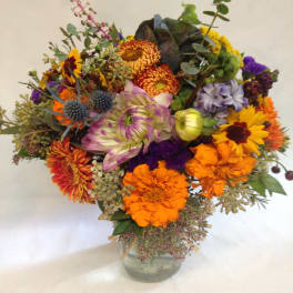 Mixed bouquet of bright flowers in a clear glass vase