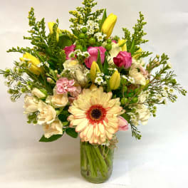 Mixed bouquet in a glass vase with pink and yellow flowers