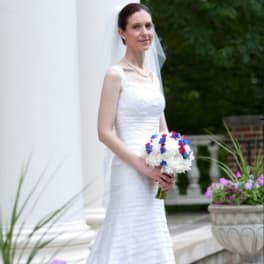 Bride in a white dress holding a white and blue bouquet