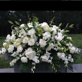 White floral casket spray with roses and lilies