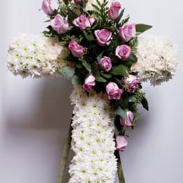 Cross-shaped floral tribute with pink roses and white chrysanthemums