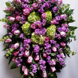 Large standing spray of pink roses, purple flowers, and green hydrangeas