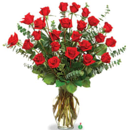 Tall arrangement of long-stemmed red roses in a clear glass vase