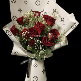Bouquet of red roses with baby's breath in patterned white wrap