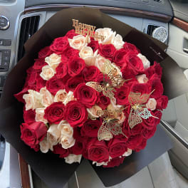 Bouquet of red and blush roses with butterfly picks and a Happy Birthday topper