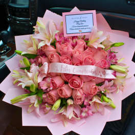 Pink rose bouquet with lilies and a birthday card in a car seat