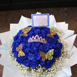 Blue rose bouquet with a tiara and butterfly decorations