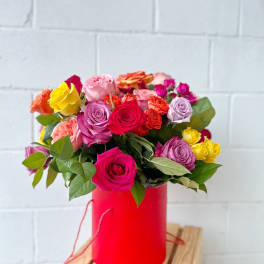 Mixed roses in a red cylindrical box