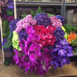 Large bouquet of pink, purple, and blue flowers with orchids and roses